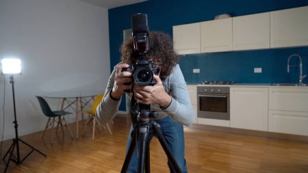 Photographer man taking pictures and video in apartment - real estate home photoshoot for selling house whit professional estate agency - home staging and enhance the property for advertising-stock-photo