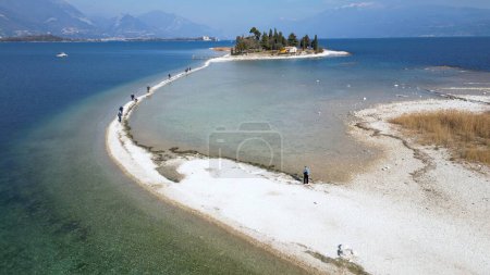 Italy, Lake Garda ,San Biagio Island , Rabbit Island - the shallow waters of the lake allow you to walk and reach the island on foot - water emergency in Lombardy , drought lowering of the water level