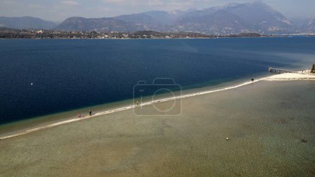 Téléchargez les photos : Italie, lac de Garde, île San Biagio, île Rabbit - les eaux peu profondes du lac vous permettent de marcher et d'atteindre l'île à pied - urgence de l'eau en Lombardie, la sécheresse abaissement du niveau d'eau - en image libre de droit