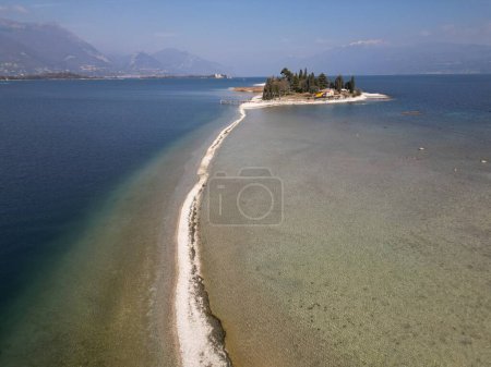 Téléchargez les photos : Italie, lac de Garde, île San Biagio, île Rabbit - les eaux peu profondes du lac vous permettent de marcher et d'atteindre l'île à pied - urgence de l'eau en Lombardie, la sécheresse abaissement du niveau d'eau - en image libre de droit