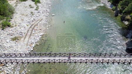 Foto de Coche pasa sobre un puente tibetano de madera que une las orillas del río - vista desde el dron en Alagna Val Sesia Piamonte montañas - viaje concepto viaje en aventura viaje natural - Imagen libre de derechos