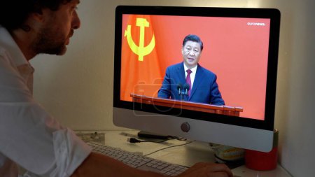 Téléchargez les photos : Europe, Milan 2023 - Regarder la télévision Nouvelles dans un ordinateur portable sur - Xi Jinping secrétaire général du Parti communiste de Chine parle de la guerre entre la Russie et l'Ukraine - en image libre de droit