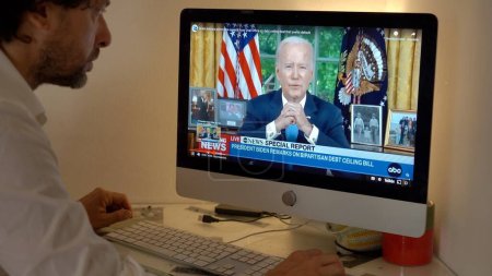 Téléchargez les photos : Europe, Milan 2023 - Regarder la télévision Nouvelles dans un ordinateur portable sur la guerre entre la Russie et l'Ukraine - Joe Biden parle à la nation américaine - en image libre de droit