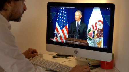 Photo for Europe, Milan 2023 - Watching Television News in a laptop computer about The War between Russia and Ukraine - Barack Obama president speaks to the Usa America nation - Royalty Free Image
