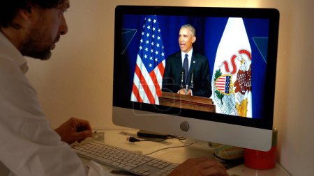 Photo for Europe, Milan 2023 - Watching Television News in a laptop computer about The War between Russia and Ukraine - Barack Obama president speaks to the Usa America nation - Royalty Free Image