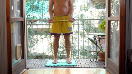 Téléchargez les photos : 40 ans homme à la maison fait gymnastique abs séance d'entraînement exercices physiques et des poids pour perdre du poids et se préparer pour l'été - activités sportives dans l'appartement balcon - en image libre de droit