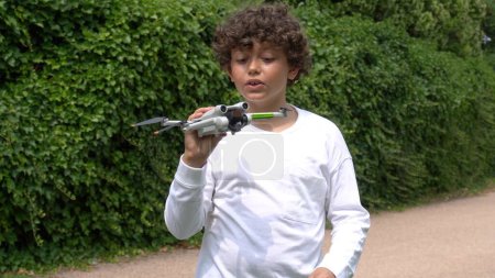 Foto de Niño niño 9 años de edad jugar y volar con drone - soñando con volar en la infancia - aprender a los niños a usar drone en seguridad con licencia - Imagen libre de derechos
