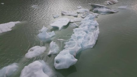 Téléchargez les photos : Vue depuis le drone de Fellaria fonte des glaciers larguant des icebergs - morceaux de glace que nous flottons dans le lac en raison du dégel à haute température - Réchauffement climatique et changement climatique en Europe, Italie Alpes - en image libre de droit