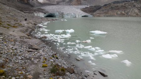 Foto de Vista desde el dron de Fellaria derritiendo glaciares cayendo icebergs - trozos de hielo que flotamos en el lago debido al deshielo de alta temperatura - Calentamiento global y cambio climático en Europa, Italia Alpes - Imagen libre de derechos