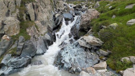 Foto de Arroyo de montaña con cascada tomada del dron - el glaciar Fellaria se derrite rápidamente y crea rápidos de agua - cambio climático y calentamiento global en Europa, Italia, Sondrio Alpe Gera - Imagen libre de derechos