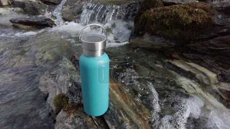 Téléchargez les photos : Remplir la bouteille d'eau dans un ruisseau de montagne - dégel des glaciers et eau potable dans la rivière - pas d'utilisation de plastique et choix écologique pour l'environnement - Sauver la planète - en image libre de droit