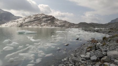 Photo for Fellaria melting glacier dropping icebergs - pieces of ice we float in the lake due to high temperature thaw - Global warming and climate change in Europe, Italy Alps - Royalty Free Image