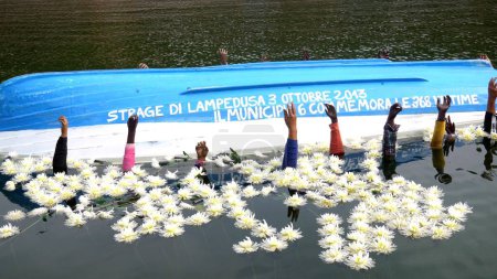 Téléchargez les photos : Europe, Milan 10-04-23 - Un bateau renversé dans la Darsena et les armes qui émergent de l'installation à Milan pour se souvenir du massacre des migrants à Lampedusa en 2013 - en image libre de droit
