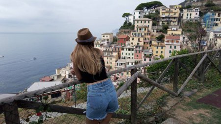 Foto de Europa, Italia, Liguria, Cinque Terre Riomaggiore - mujer turista con sombrero de visita La atracción turística de Cinque Terre para los turistas de todo el mundo Patrimonio de la Unesco - destino turístico - Imagen libre de derechos