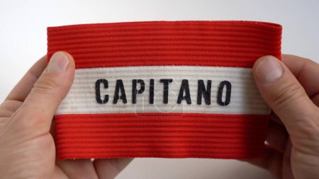 Photo for Man's hands hold football captain's armband won when he was a child in childhood - remembering past successes that led to becoming adults and growing self-esteem - Royalty Free Image