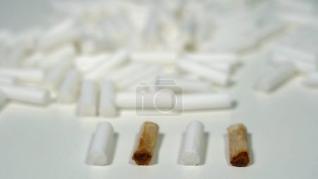 Photo for Cotton smoking cigarette filters for making cigarettes with tobacco - reduce the damage from smoking with new, white filters - smoke addiction - Royalty Free Image