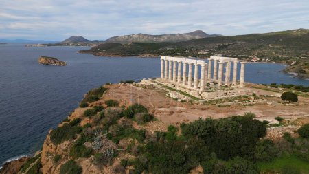 Photo for Temple of Poseidon is one of the most famous monuments in Greece, perched on a rocky Cape Sounion overlooking the Mediterranean sea. - Royalty Free Image