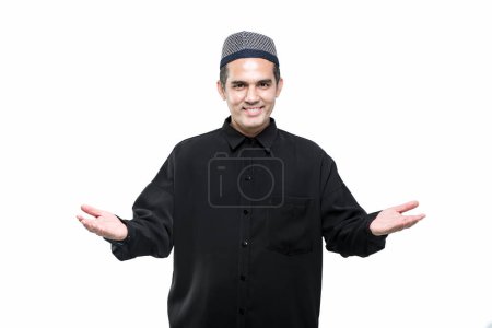 Photo for A handsome Asian Muslim man is welcoming and greeting with a smiling face. - Royalty Free Image