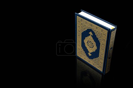 Concept islamique - Le Saint Coran avec la signification écrite de la calligraphie arabe d'Al Coran et chapelet perles ou tasbih, traduction arabe des mots : Le Saint Coran (livre sacré de Musulman)