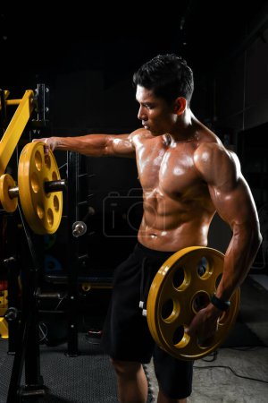 Foto de Imágenes de hombres asiáticos con hermosos músculos levantando pesas en el gimnasio. - Imagen libre de derechos