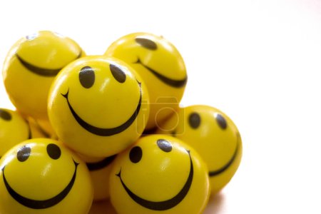 many yellow colored smiley balls with white background