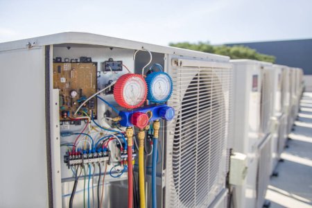 Téléchargez les photos : L'ingénieur vérifie le fonctionnement du climatiseur, vérifie la pression, remplit et remplit le réfrigérant de climatisation. - en image libre de droit