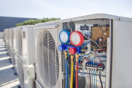 Téléchargez les photos : L'ingénieur vérifie le fonctionnement du climatiseur, vérifie la pression, remplit et remplit le réfrigérant de climatisation. - en image libre de droit