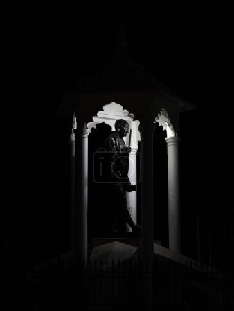 Foto de Estatua de un líder indio de la libertad Mahatma Gandhi en la noche, la estatua está protegida bajo una cúpula Pondicherry, India - Imagen libre de derechos