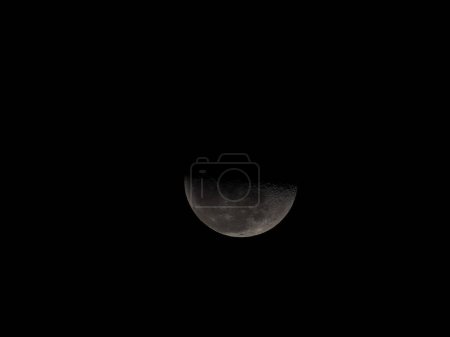 a half moon in dark black sky