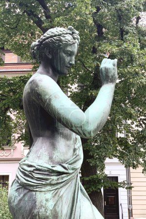 la statue d'une femme Muse de l'Histoire avec une fleur
