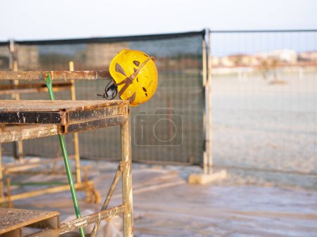 Helmet and safety glasses (example of personal protective equipment used to enhance workplace safety) resting on a scaffold in a construction sit