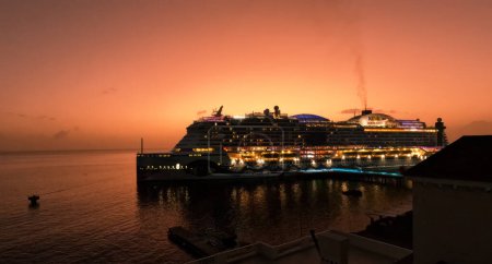 Téléchargez les photos : La silhouette d'un bateau de croisière contre un coucher de soleil orange à Roseau, Dominique - en image libre de droit