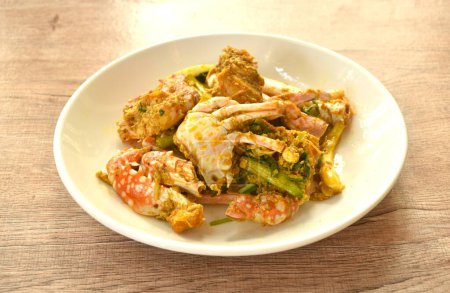 stir fried swimmer crab in yellow curry and egg on plate 