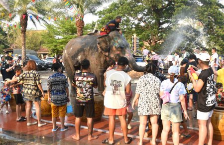 Téléchargez les photos : Ayutthaya Thaïlande Avril 14, 2024 : éléphant éclaboussant l'eau entre les touristes dans le festival Songkarn - en image libre de droit