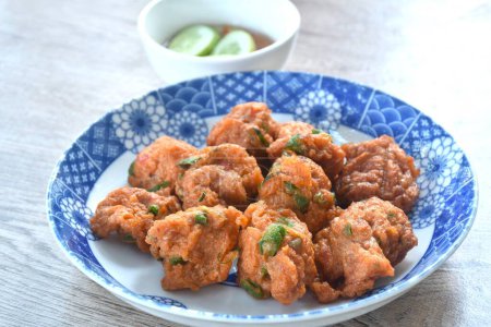 deep fried fish patty on plate with slice cucumber dipping sweet chili sauce 