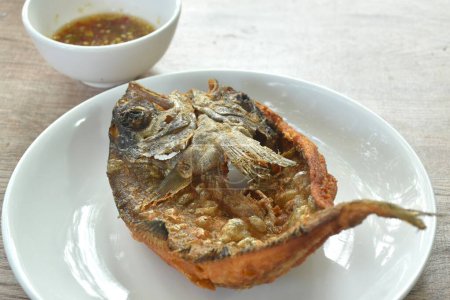 Photo for Deep fried black-banded trevally fish on plate dipping spicy chili sauce - Royalty Free Image