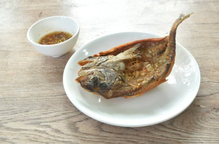 Photo for Deep fried black-banded trevally fish on plate dipping spicy chili sauce - Royalty Free Image