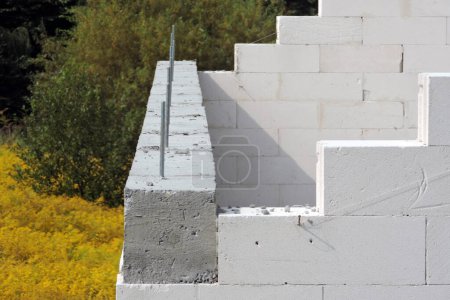 Photo for Construction steel pins, a reinforced concrete beam and steel bars on the first floor of a house under construction, walls made of autoclaved aerated concrete - Royalty Free Image