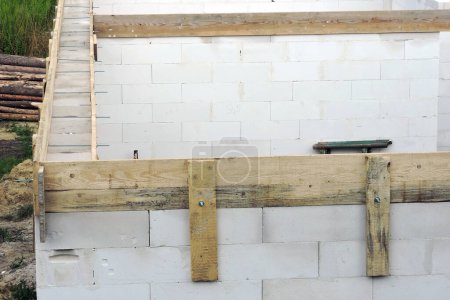Photo for A wooden formwork joined with metal pins for a reinforced concrete band on the first floor of a house under construction, walls made of autoclaved aerated concrete - Royalty Free Image