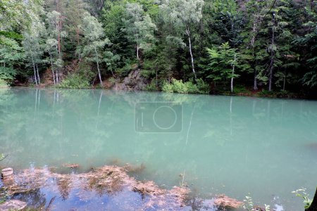 Photo for A view of an azure lakelet among trees in Rudawy Janowickie, Sudetes mountains, Poland - Royalty Free Image