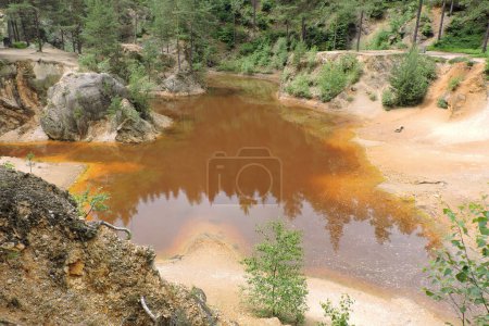 Photo for A view of a purple lakelet in Rudawy Janowickie, Sudetes mountains, Poland, a mining excavation flooded with water - Royalty Free Image