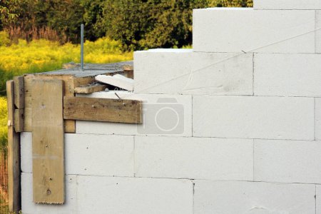 Photo for A construction pin, a reinforced concrete beam, steel bars and a wooden formwork on the first floor of a house under construction, walls made of autoclaved aerated concrete - Royalty Free Image
