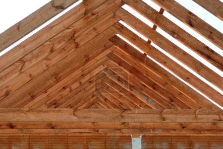 Foto de A timber roof truss of a house under construction, reinforced brick lintels, grey sky in the background - Imagen libre de derechos