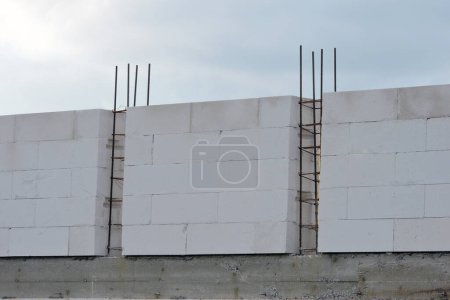 Photo for A reinforced concrete beam, steel reinforcement for pillars on the first floor of a house under construction,  walls made of aac - Royalty Free Image