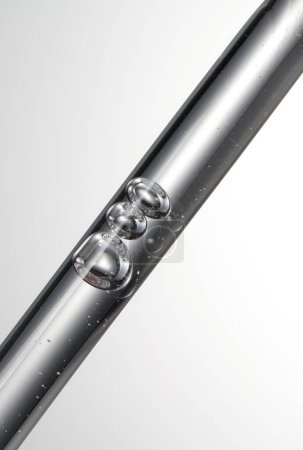 Foto de La punta de un tubo de laboratorio de vidrio está goteando un líquido - Imagen libre de derechos