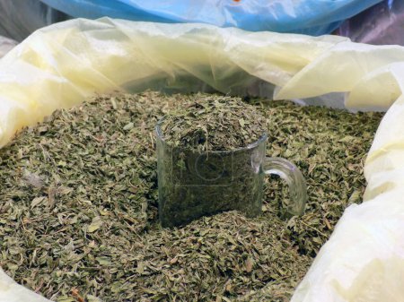 Foto de La medicina herbal - las hojas secas de Verano salado (Satureja hortensis) en la bolsa de plástico en el puesto de mercado - Imagen libre de derechos