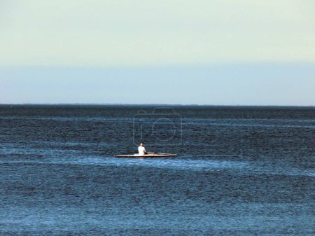 Photo for Lonely man in the rowboat in the middle of the sea - Royalty Free Image