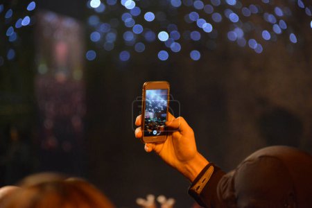 Foto de Tenía y mano de la chica que grababa el escenario con un teléfono móvil durante un concierto - Imagen libre de derechos