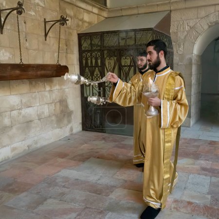 Foto de Jerusalén, Israel - 12 de noviembre de 2022: sacerdotes armenios balancean incienso en las afueras de la catedral de Santiago, Jerusalén, Israel. - Imagen libre de derechos