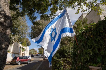 Eine israelische Flagge, die auf einer Straße in Israel gehisst wird, um Einigkeit und Unterstützung im Kampf gegen den islamischen Terror zu zeigen.